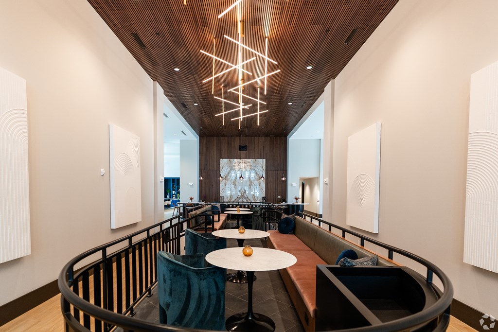 a large lobby with tables and chairs and a large chandelier at Preston Ridge, Cary, NC